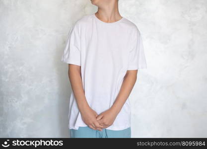 Clothing sale, place for logo, advertising, collaboration, white T-shirt, print, place for text, close-up, children’s clothing. The child is wearing a white T-shirt. Place for advertising