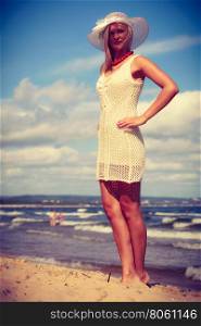 Clothing, summer time concept. Attractive woman with white dress. Lady enjoying sunny weather by the seaside.