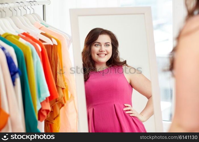 clothing, wardrobe, fashion, style and people concept - happy plus size woman posing at mirror at home