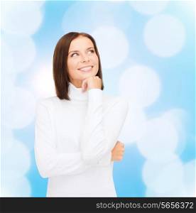 clothing, winter holidays, christmas and people concept - smiling young woman in white sweater over blue lights background