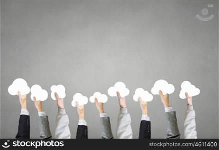 Cloud computing concept. Many hands of business people holding cloud symbol on color background