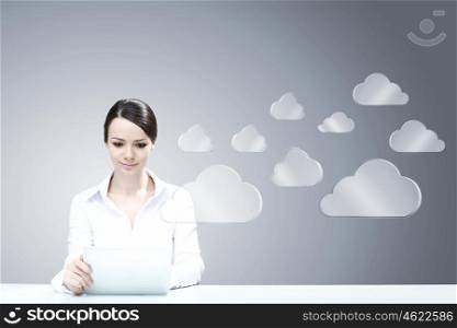 Cloud computing connection. Attractive businesswoman sitting at table and using tablet