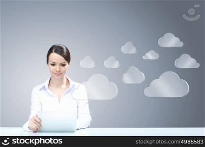 Cloud computing connection. Attractive businesswoman sitting at table and using tablet
