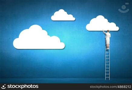 Cloud computing. Rear view of businesswoman standing on ladder and reaching cloud