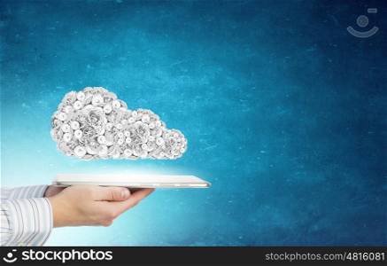 Cloud computing. Tablet pc in hands and gears symbol