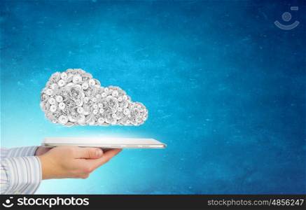 Cloud computing. Tablet pc in hands and gears symbol