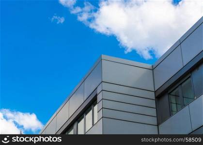 Cloud game, a house facade in front of a blue Hhimmel with white clouds.