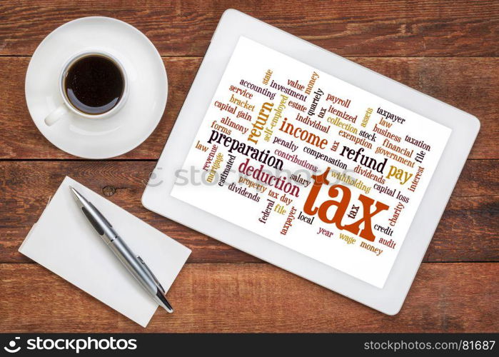 cloud of words related to taxes, preparation, paying, income, refunds on a digital tablet with a cup of coffee