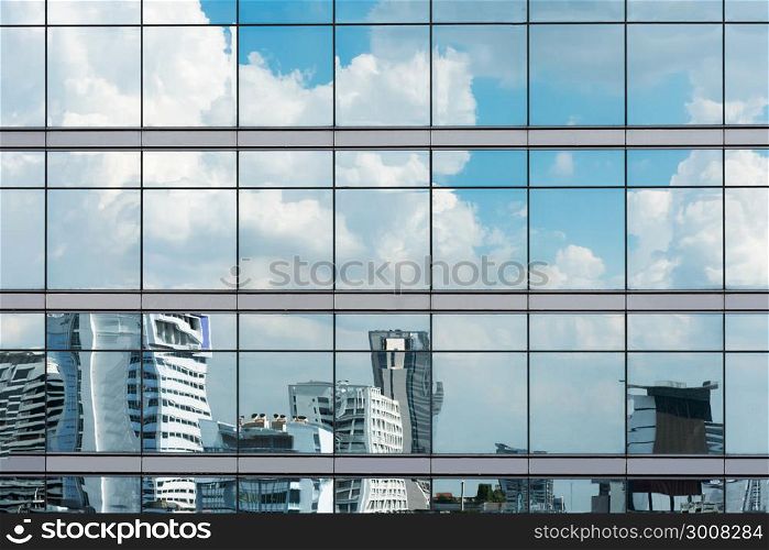 Cloud reflection in high glass offices. Blue reflection of the sky. Windows of a building. Business background. Business construction.