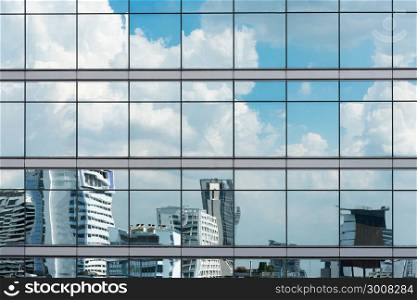 Cloud reflection in high glass offices. Blue reflection of the sky. Windows of a building. Business background. Business construction.