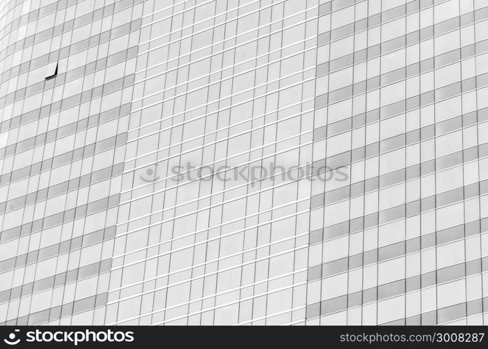 Cloud reflection in high glass offices. Blue reflection of the sky. Windows of a building. Business background in monochrome.