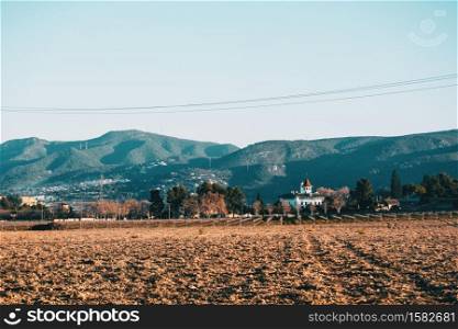 Cloudless landscape in an agricultural field in winter with a house isolated in the nature