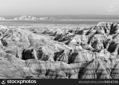 Clouds allow the sun to light rock formations in the South Dakota Badlands