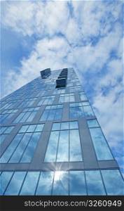 Clouds and blue sky reflection in glass skyscraper. Reflection