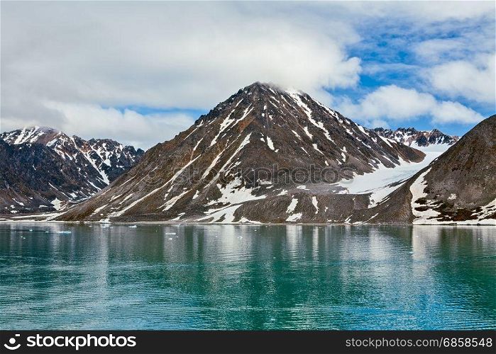 Clouds and mountains along the Magdalenafjord in Svalbard islands, Norway. Magdalenafjord in Svalbard islands, Norway