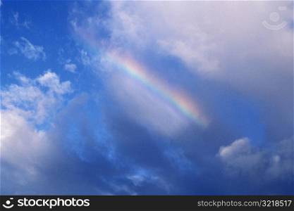 Clouds and Rainbow in Blue Sky