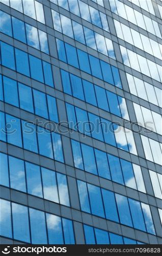 Clouds and sky reflection on a glass building facade.