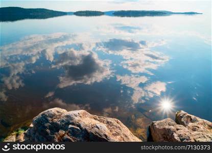 Clouds and sun with reflection in the water on the lake . Ladoga Skerries, Karelia. Clouds and sun with reflection in the water on the lake . Ladoga Skerries, Karelia.