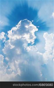 clouds in blue sky with sun rays