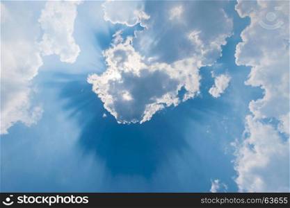 clouds in blue sky with sunrays