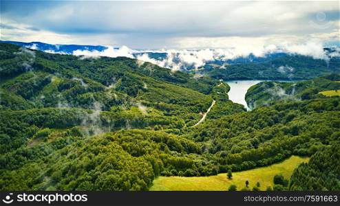 Clouds of fog after summer rain. Summer landscape with lake and mountain woodland. Aerial view of Reservoir/lake Starina, Poloniny national park, Slovakia.