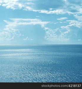 Clouds over still ocean waters