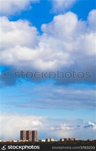 clouds over urban apartment houses in spring day