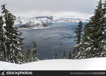 Clouds roll by the north rim at Crater Lake towards Mt Scott in the winter