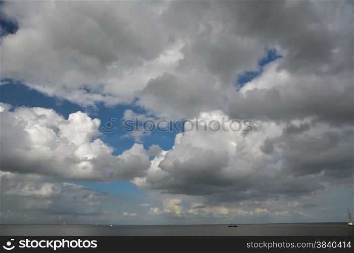 cloudscape above lake with boats