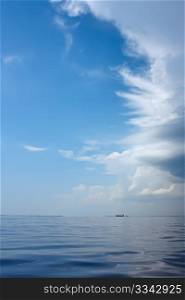 Cloudscape over the sea near the coast. Big ship sailing on the horizon