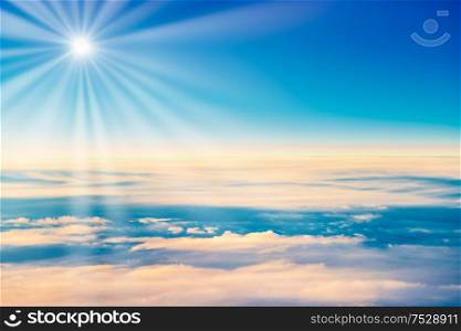 Cloudscape with clear blue sky, sun and fluffy clouds, view from above