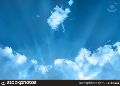 cloudscape with sunbeams, bright blue sky with white clouds on it. cloudscape with sunbeams