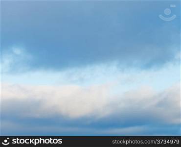 cloudscape with with gray winter clouds in blue afternoon sky