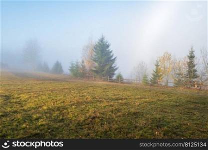 Cloudy and foggy morning late autumn mountains scene. Peaceful picturesque traveling, seasonal, nature and countryside beauty concept scene. Carpathian Mountains, Ukraine.