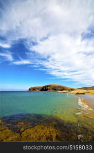 cloudy beach light water in lanzarote isle foam rock spain landscape stone sky