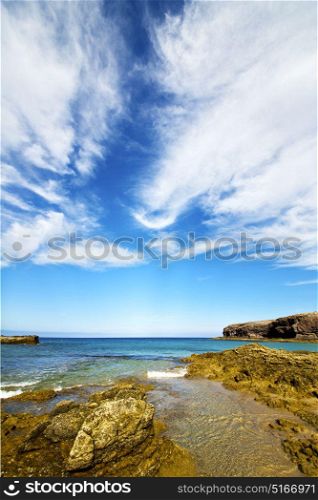 cloudy beach light water in lanzarote isle foam rock spain landscape stone sky