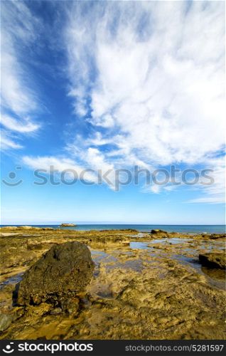 cloudy beach light water in lanzarote isle foam rock spain landscape stone sky
