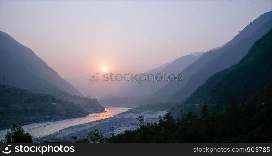 Cloudy landscape view of sunset over Indus river and layers of Karakoram mountain range, Khyber Pakhtunkhwa, Pakistan.