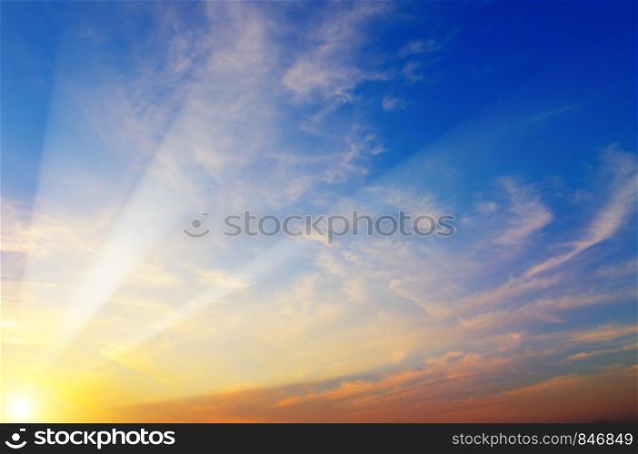 Cloudy sky and bright sun rise over the horizon.