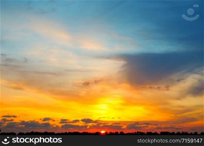 Cloudy sky and bright sunset over the horizon.