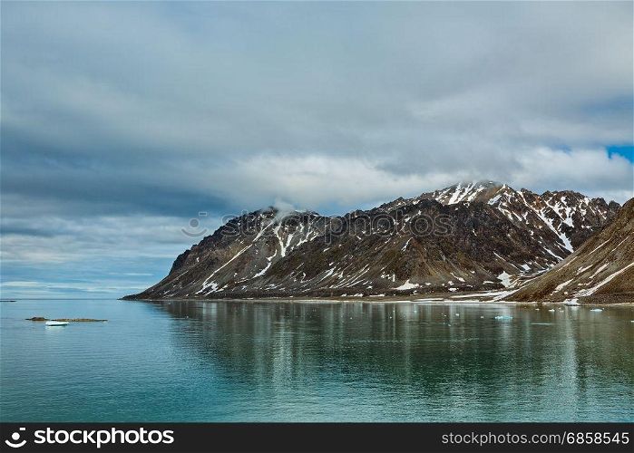 Cloudy sky and mountains along the Magdalenafjord in Svalbard islands, Norway. Magdalenafjord in Svalbard islands, Norway