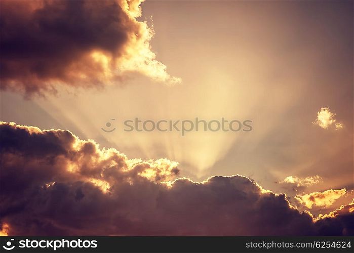 Cloudy sky background, bright sunbeams through dark clouds, message from God, overcast autumn weather