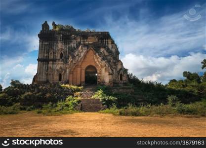 Cloudy sky over amazing architecture of old Buddhist Temple ruins at Inwa city near Mandalay. Myanmar (Burma) travel landscapes and destinations