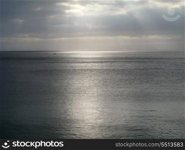 Cloudy sky with rays of light over the sea