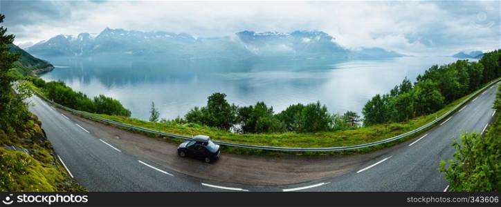 Cloudy summer view over Glomfjorden, Nordland, Norway. Travellers car on road.