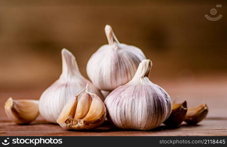 Cloves of fresh garlic on the table. On a wooden background. High quality photo. Cloves of fresh garlic on the table.