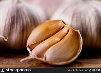 Cloves of fresh garlic on the table. On a wooden background. High quality photo. Cloves of fresh garlic on the table.