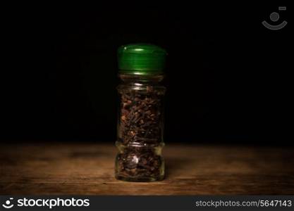 Cloves on wooden surface and black background