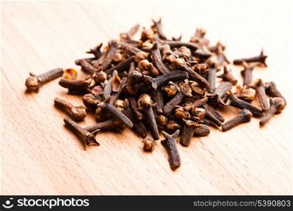 Cloves spice scattered on wooden table