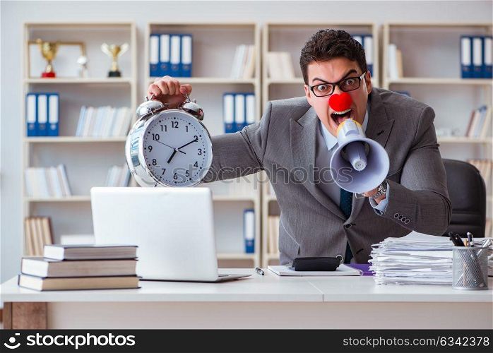 Clown businessman angry in the office with a megaphone